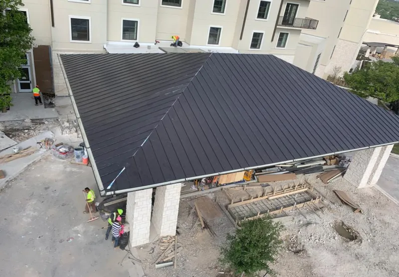 Metal roofing installation team working on a commercial building in Pleasant View